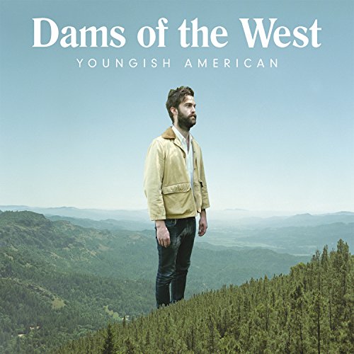 Man standing on a forested hill with mountains in the background, album cover artwork.