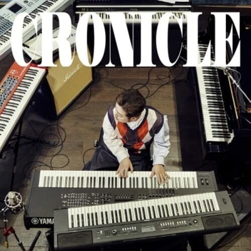 Sunghoon sits at a keyboard surrounded by musical equipment.