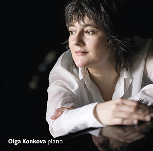 "Album cover featuring a woman with dark hair, wearing a white shirt, resting on a piano."