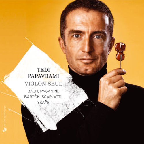 Man in black shirt holds miniature violin on stick, against orange background with text overlay.