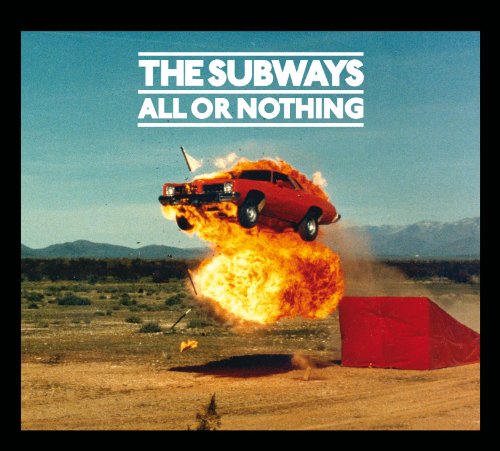 Album cover: burning red car airborne against desert landscape.