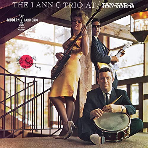 Album cover featuring a trio of musicians with guitars and drums.