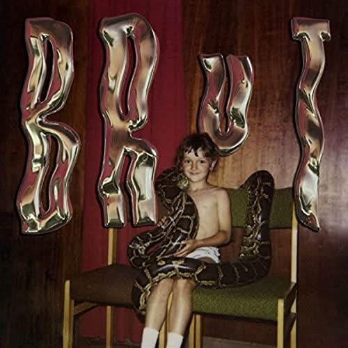 Album cover: child with a snake, metallic letters spelling "BRUT".