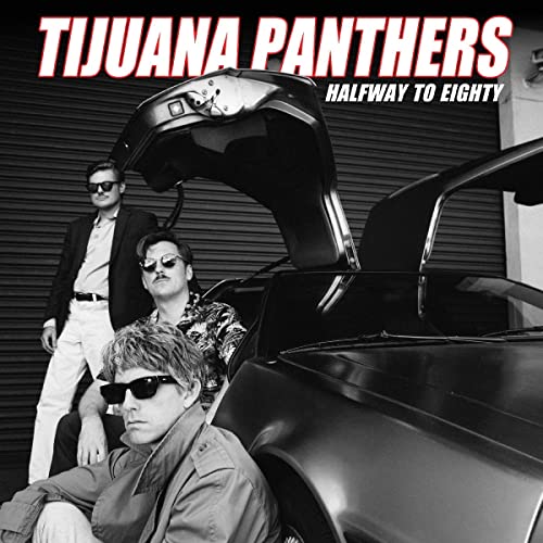 Three men in sunglasses pose by an open car trunk.