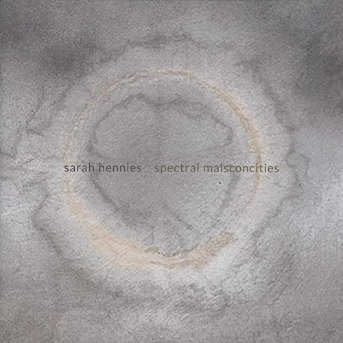 The image is a CD cover with a grey, textured background and a circular design. #### Alt text: Grey textured CD cover with circular design and artist/album title text overlay.