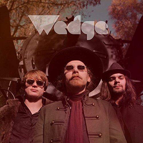 Album cover for “Wedge” featuring three men with a train backdrop.
