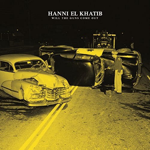 "Album cover with damaged cars on a road, man standing beside wreckage at night."