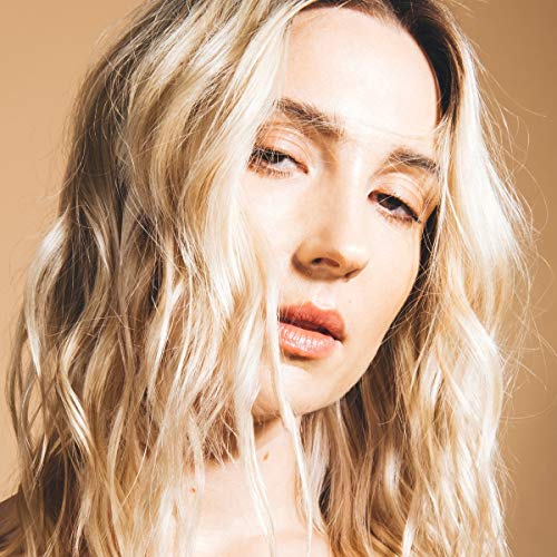 Close-up portrait of Ali Barter with wavy blonde hair and neutral makeup.