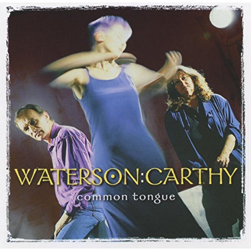 "Album cover with three blurry performers and yellow title text on a dark background."