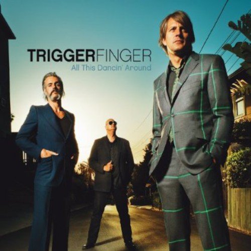 "Album cover featuring three men in suits standing on a suburban street."