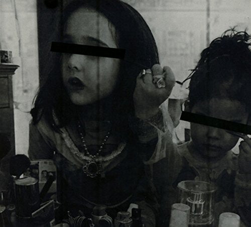 Black and white image of two children with censored faces at a table.
