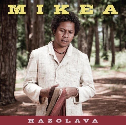 "Album cover featuring a man in a white jacket holding fabric in a forest."