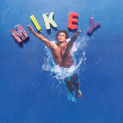 Man emerging from blue water with candles spelling “MIKEY” above.