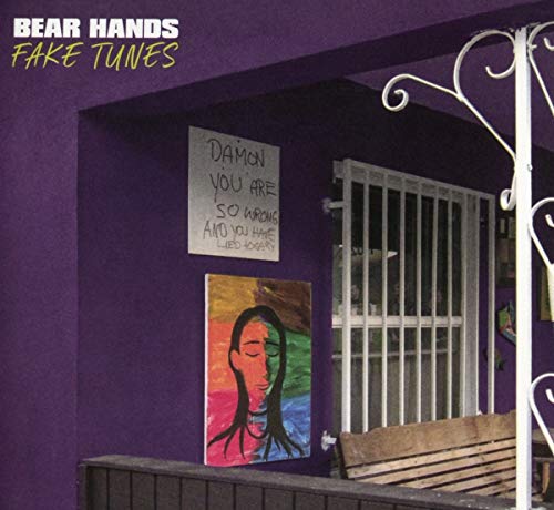 "Purple building with a poster and a wooden bench outside a barred window."