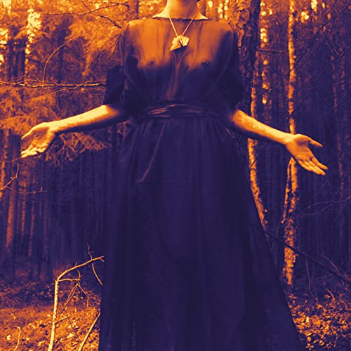 Woman in dark dress with outstretched arms in a forest.