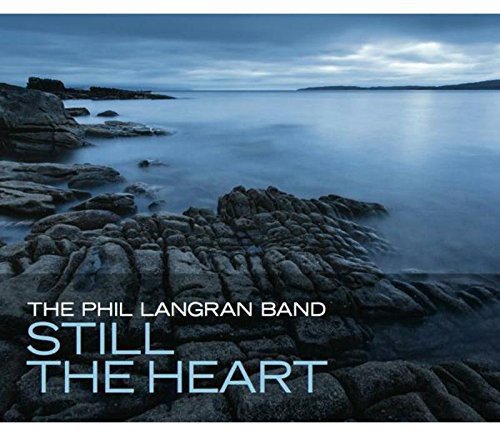 "Album cover with rocky shoreline, calm water, and cloudy sky, featuring 'The Phil Langran Band'."