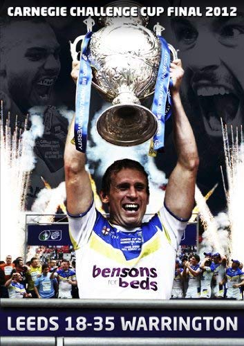 Rugby player lifting a trophy with fireworks and a crowd background.