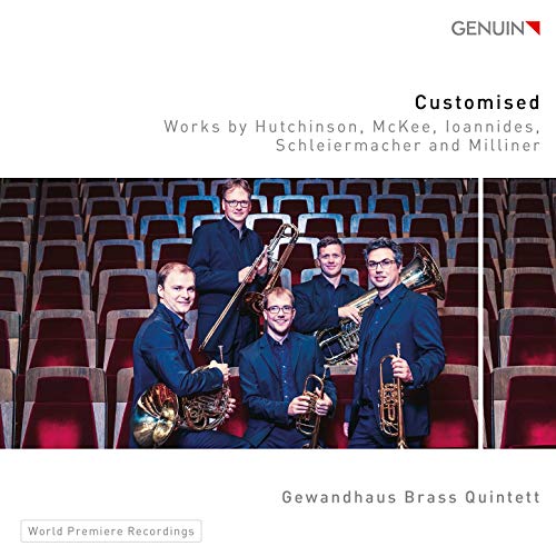Brass quintet posing in a concert hall with their instruments.