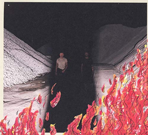 Two figures stand in a dark, cavernous space with painted flames.