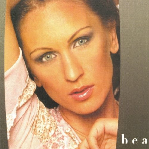 "CD cover featuring a woman with blue eyes and dark hair, wearing a pink top."