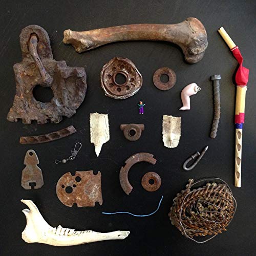 A collection of rusty metal parts, bones, and trinkets on a black background.