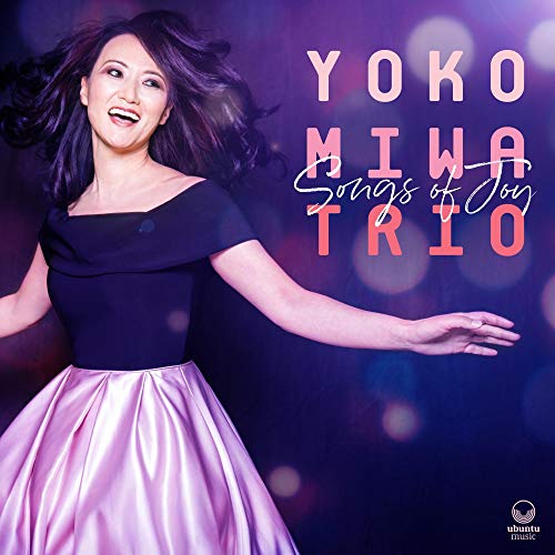 CD cover featuring a smiling woman in a pink skirt and black top.