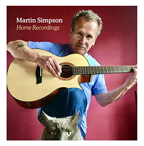 Album cover with man holding guitar and a cat below him.