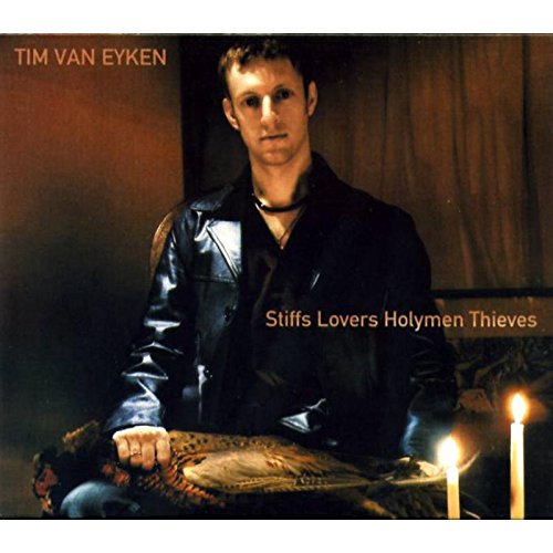 "Album cover featuring a man in black leather jacket with two lit candles."