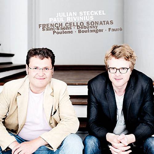 "CD cover featuring two men sitting on stairs, wearing casual jackets and jeans."