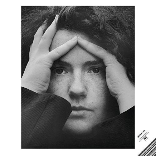 Black and white album cover featuring a man with hands on his forehead.