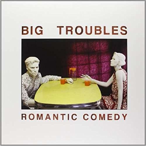 "Album cover with man and woman reaching for a yellow table."