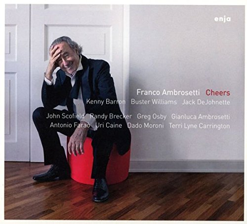 "Album cover with a man sitting on a red stool, hand on his head."