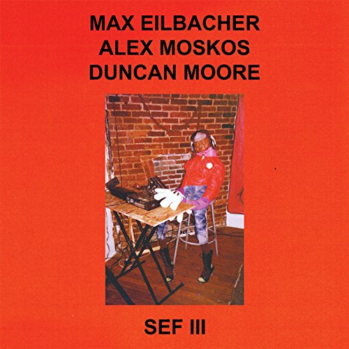 "Red album cover with a man sitting at a table with turntables."