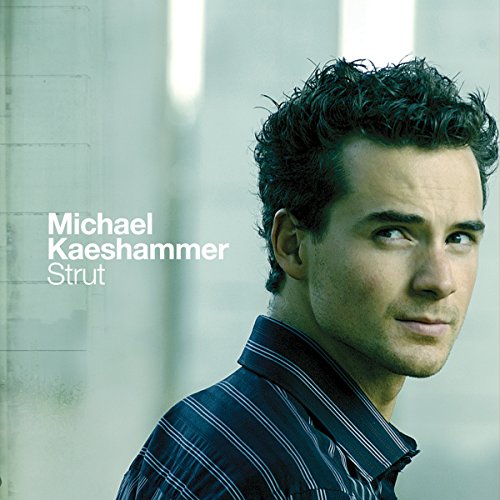"Album cover featuring a man with curly hair and a striped shirt."