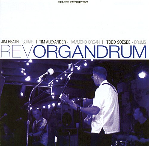"Album cover featuring a band performing on stage with spotlights and microphones."