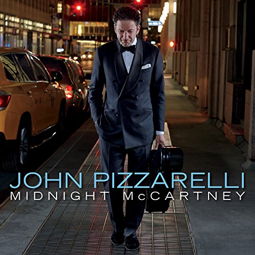 "Album cover: man in tuxedo walking down city street at night, carrying a guitar case."