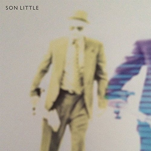 Album cover with a blurry man in a suit and hat walking.
