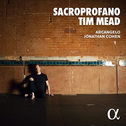 CD cover: man sitting against a textured orange brick wall.