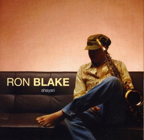 "Album cover: man sitting on couch holding saxophone, wearing cap and casual clothing."