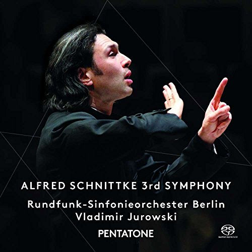 Conductor in black, arms raised, on a dark background with white text overlay.