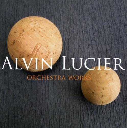 "CD cover with two beige spheres on a blue textured background, titled 'Alvin Lucier Orchestra Works'."