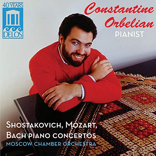 CD cover featuring a man in a red sweater leaning on a piano.