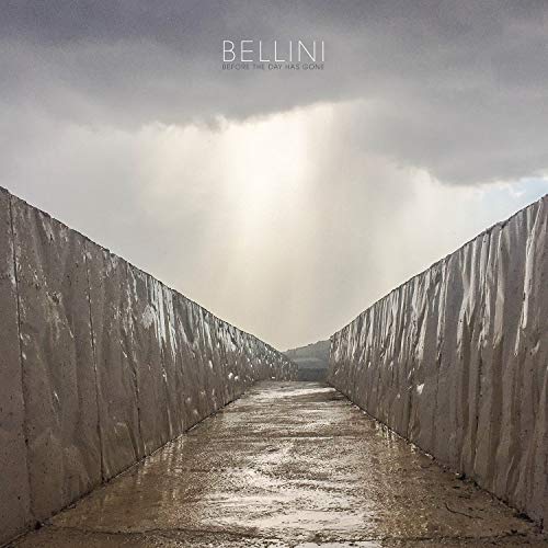CD cover with a road between concrete walls under a cloudy sky.