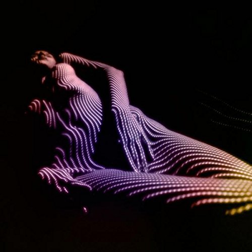 A woman reclines, her body adorned with a grid pattern of colorful lights.