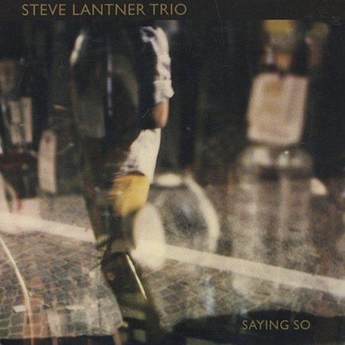 Blurry album cover with a person walking on a tiled floor, text at top and bottom.