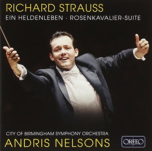 Conductor Andris Nelsons in a black tuxedo, holding a baton, against a black background.