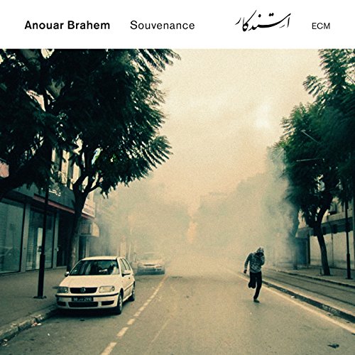 "CD album cover with a foggy street scene and a person walking."