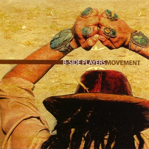 "CD album cover with a person wearing a hat, hands raised, and ornate rings."