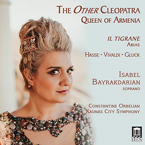 The image depicts a CD cover for "The Other Cleopatra" featuring Isabel Bayrakdarian. * The cover includes the title and subtitle "The Other Cleopatra" and "Queen of Armenia". * The cover art showcases a woman with blonde hair styled in an updo, adorned with jewelry, and wearing a decorative top. * The image is in muted colors, with a soft focus effect. * The text on the cover is in red, with the title and subtitle promin