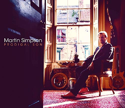 Martin Simpson sitting in a chair by a window with guitars nearby on album cover.